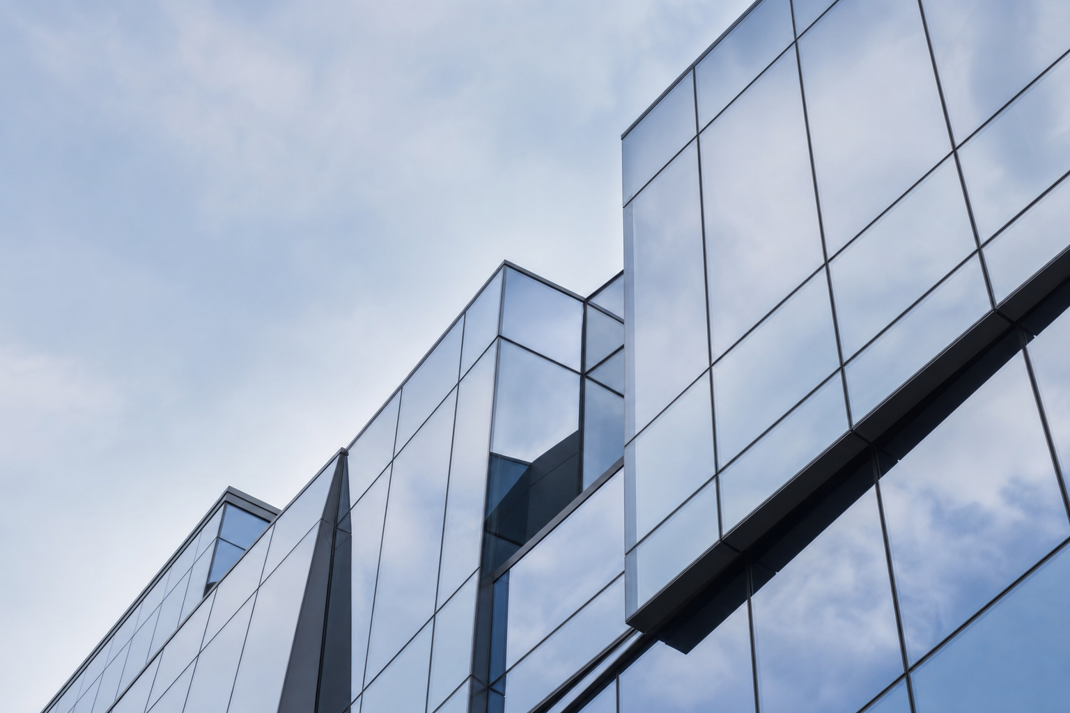Modern glass building facade abstract geometric lines editorial context